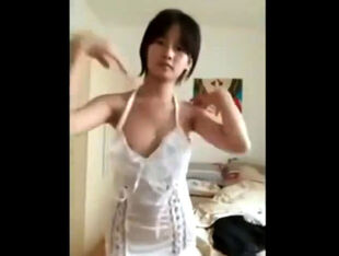 Cute chinese teen blinking atop webcam